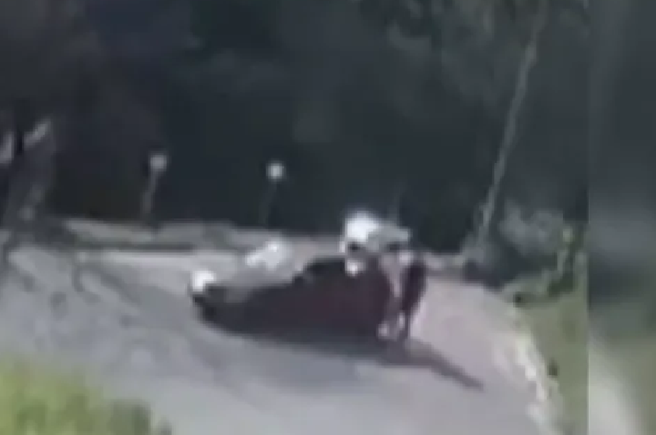 Homem segura cachorro e amigo passa por cima da cabeça com carro, em SC